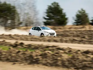 Biały Peugeot 208 Rally2 RallyZone na drodze szutrowej